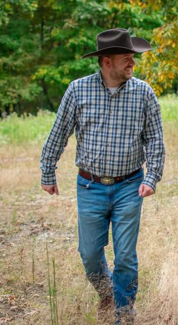 Jeremy Farley walking outdoors in a cowboy hat
